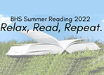 Open book laying on grass with the words Read, Relax, Repeat