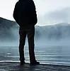 Man standing on water's edge 